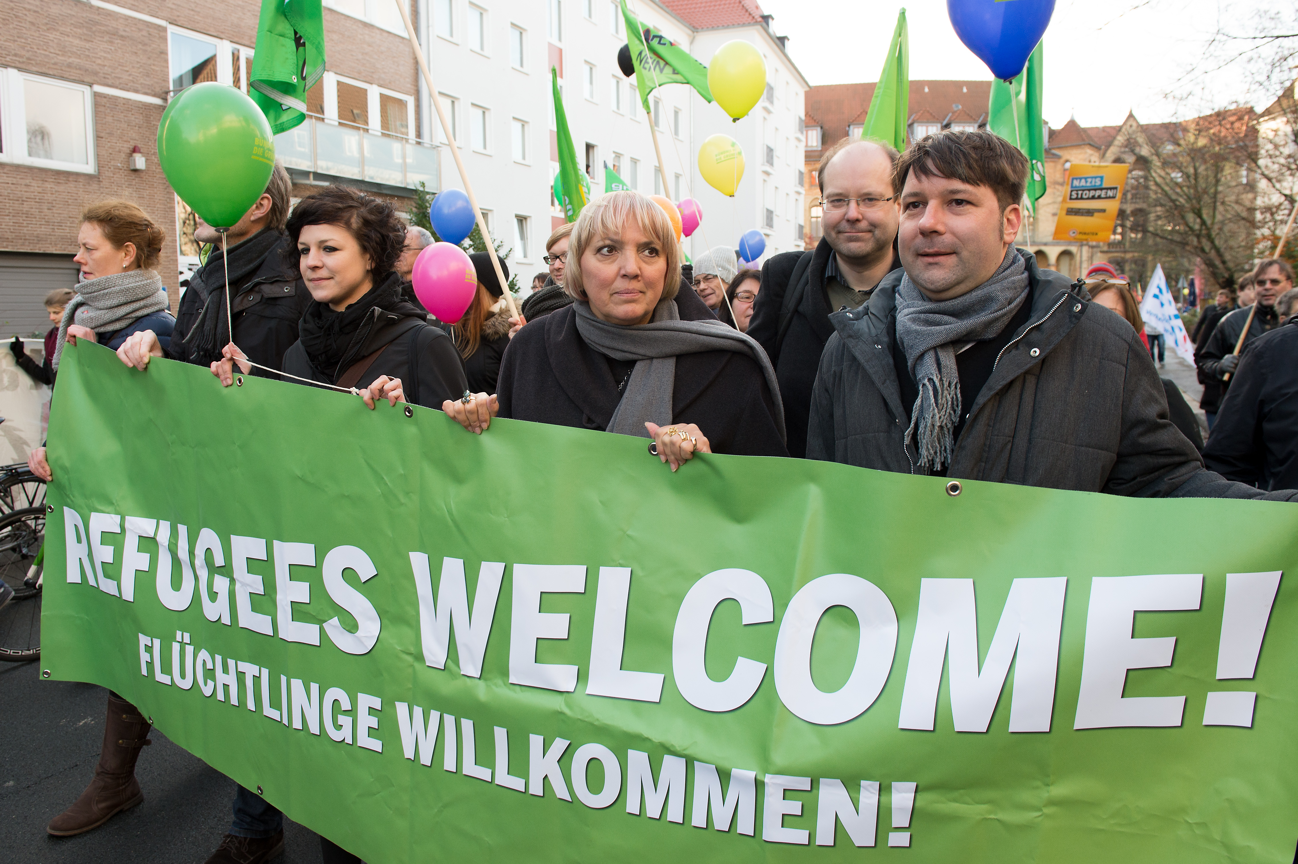 Claudia Roth (M), Niedersachsens Landwirtschaftsminister Christian Meyer (2.v.r.) und der grüne Landesvorsitzende in Niedersachsen, Stefan Körner (r, alle Bündnis 90/Die Grünen), gehen am 28.11.2015 bei einer Gegendemonstration des Bündnisses "Bunt statt Braun" zum 4. Bundesparteitag der Alternative für Deutschland (AfD) in Hannover (Niedersachsen) mit einem Transparent mit der Aufschrift "Refugees welcome, Flüchtlinge willkommen