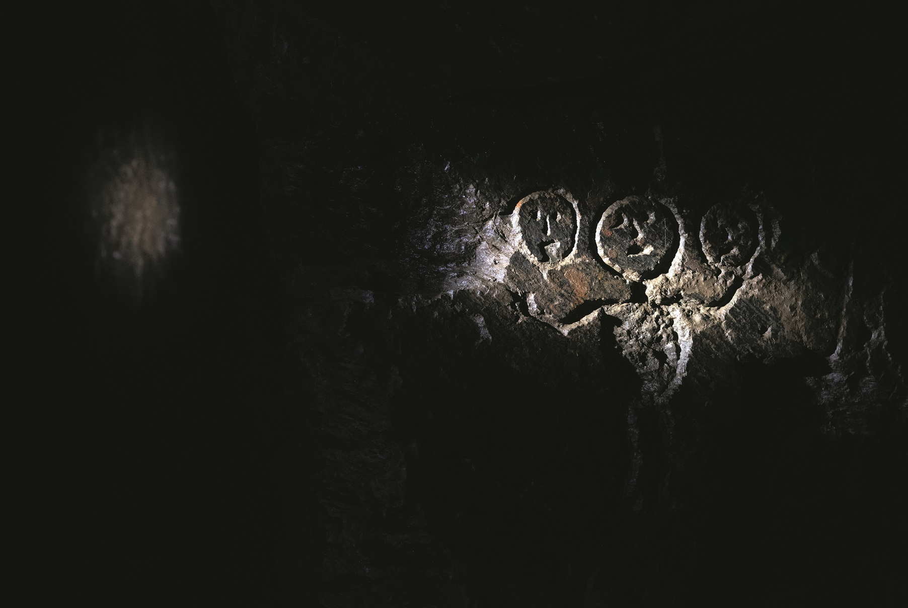 Eine historische Markierung an einer Steinwand erinnert an den Tod dreier Bergmänner