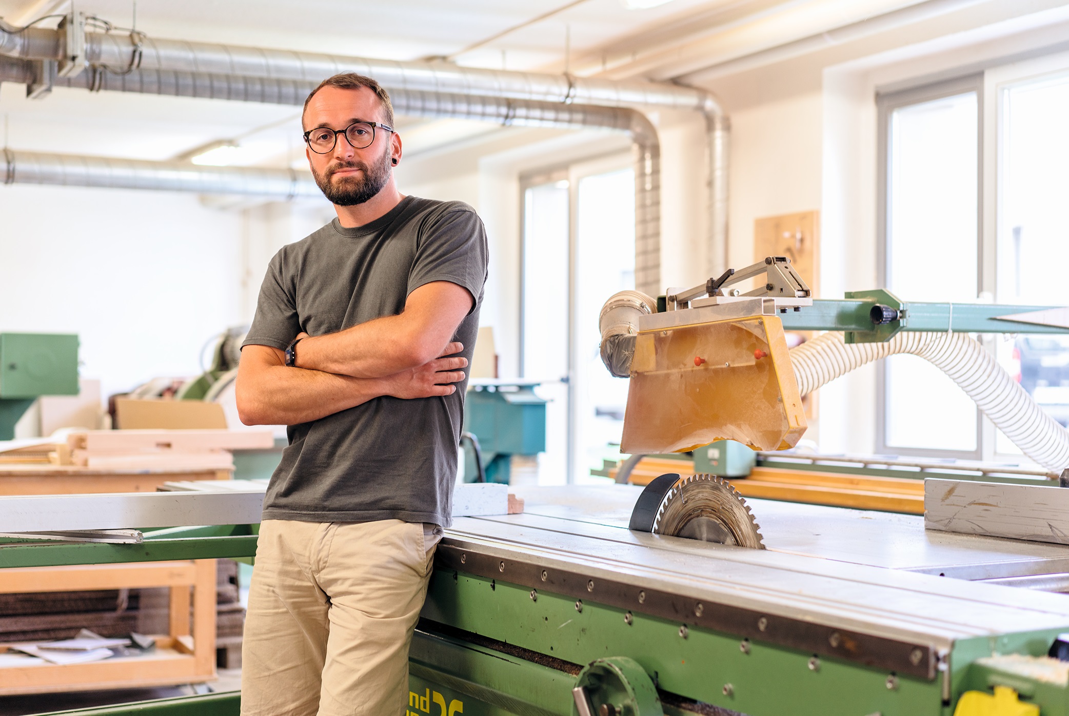 Lars Dahlitz sitzt an einem Tisch mit Kreissäge gelehnt