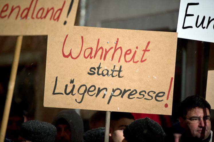 Pegida-Anhänger halten ein Schild mit der Aufschrift „Wahrheit statt Lügenpresse“ hoch
