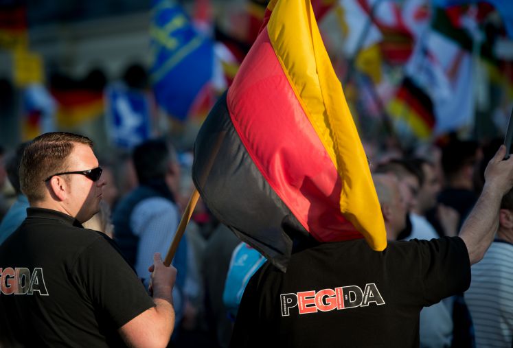 Teilnehmer einer Pegida-Kundgebung mit Deutschlandfahne