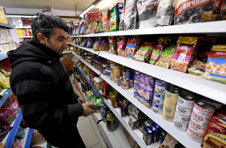 Der Syrer Ahmed Alsamiye steht vor einem Supermarkt-Regal 