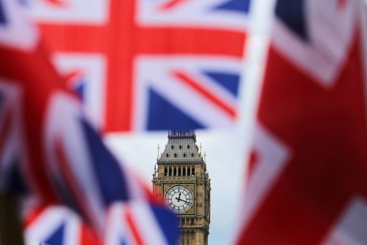 Big Ben, um ihn sind Flaggen Großbritanniens zu sehen.