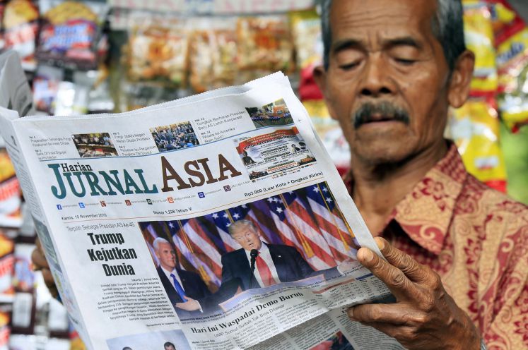 Ein Mann liest eine asiatische Zeitung.