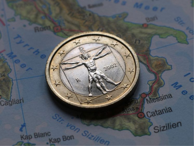 Eine italienische Euromünze auf der Landkarte Italiens. 