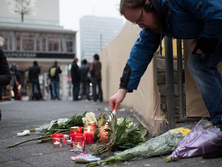Ein Mann zündet eine Kerze für die Opfer des Berliner Anschlags an