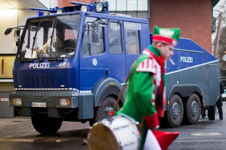 Ein Musiker einer Garde passiert am 23.02.2017 einen Wasserwerfer der Polizei vor dem Alter Markt in Köln (Nordrhein-Westfalen). Im Rheinland und anderswo beginnt an Weiberfastnacht oder Altweiber der Straßenkarneval unter verstärkten Sicherheitsvorkehrungen