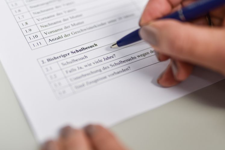 Eine Person füllt eine Umfrage über ihren bisherigen Schulbesuch aus.