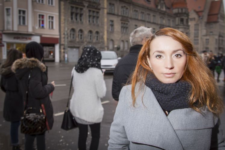 Zana Ramadani steht vor Mädchen mit Kopftüchern