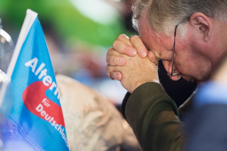 Alexander Gauland sitzt in Kremmen auf dem Landesparteitag der AfD mit gefalteten Händen auf seinem Platz