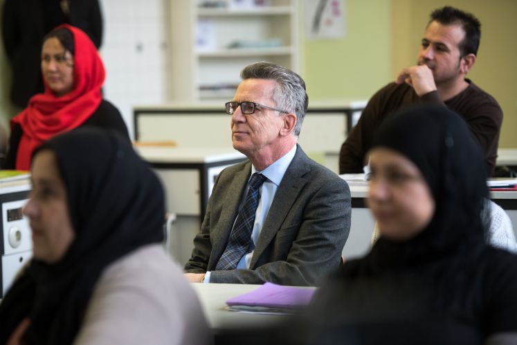 Innenminister Thomas de Maizière (CDU) bei einem Besuch von einem Orientierungskursus für Asylbewerber in Berlin