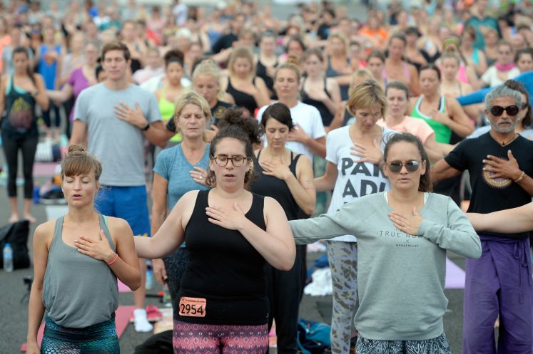 Zahlreiche Teilnehmer machen in Berlin auf dem Tempelhofer Feld Yoga-Übungen