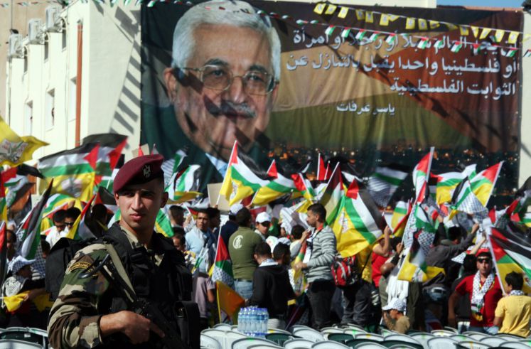 Palästinenser demonstrieren mit einer Flagge, die Mahmud Abbas zeigt