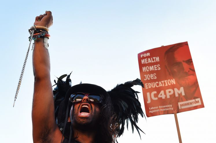 Ein Unterstützer von Jeremy Corbyn reckt vor einem Poster mit dem Konterfei des Labour-Chefs die Faust in die Höhe