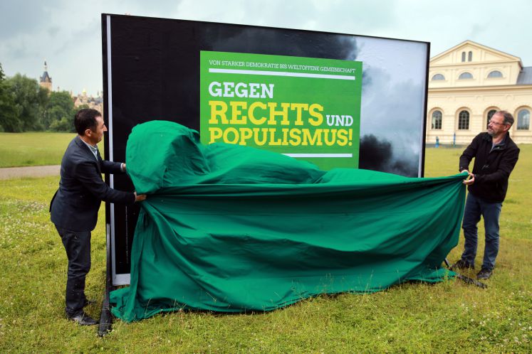Der Grünen-Bundesvorsitzenden Cem Özdemir (l) und der Fraktionsvorsitzende der Grünen im Landtag von Mecklenburg-Vorpommern, Jürgen Suhr (r), enthüllen am 14.06.2016 in Schwerin (Mecklenburg-Vorpommern) ein Wahlplakat mit der Aufschrift "Gegen Rechts und Populismus".