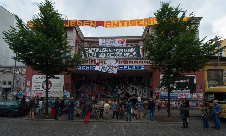Man sieht frontal die rote Flora mit diversen Schriftzügen zu Kapitalismus.