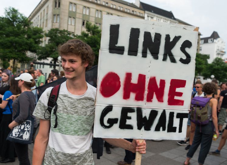 Ein Demonstrant hält am 19.07.2017 in Hamburg ein Schild mit der Aufschrift «Links ohne Gewalt» in den Händen. 