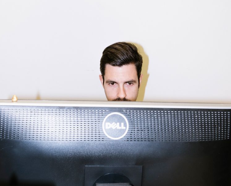 Ein Mann sitzt vor einem Computerbildschirm.