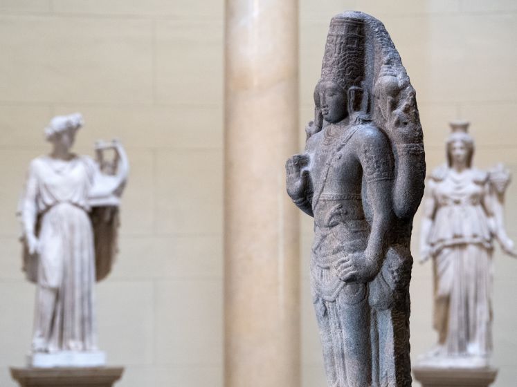 Skulpturen verschiedenster mythischer Figuren, darunter im Vordergrund der Indische Gott Shiva 