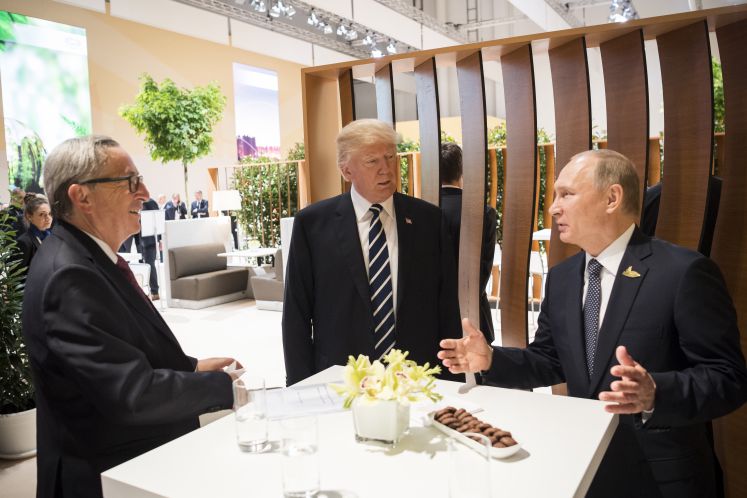 Der US-amerikanische Präsident Donald Trump (M)und der russische Präsident Wladimir Putin (r) unterhalten sich am 07.07.2017 in Hamburg beim G20-Gipfel.