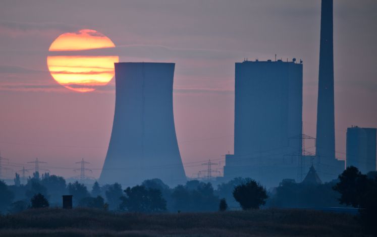 Die aufgehende Sonne steht am 22.08.2017 hinter dem Steinkohlekraftwerk Mehrum bei Hohenhameln (Niedersachsen).