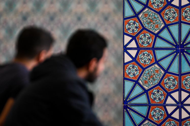 Zwei junge Muslime hören am 03.10.2017 in Hamburg in der Centrum Moschee einem Vortrag zu.