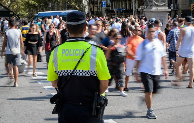 Ein Polizist beobachtet am 18.08.2017 den Fußgängerverkehr auf einer Kreuzung an der Flaniermeile Las Ramblas in Barcelona (Spanien). 