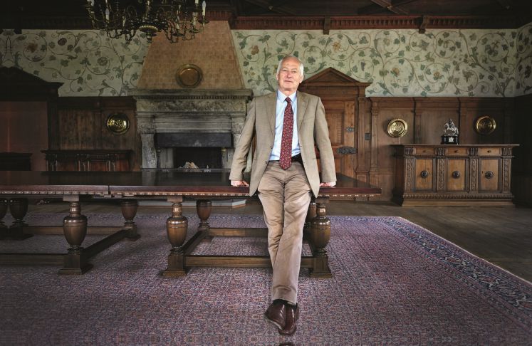 Fürst Hans-Adam II. von und zu Liechtenstein an einen Tisch gelehnt