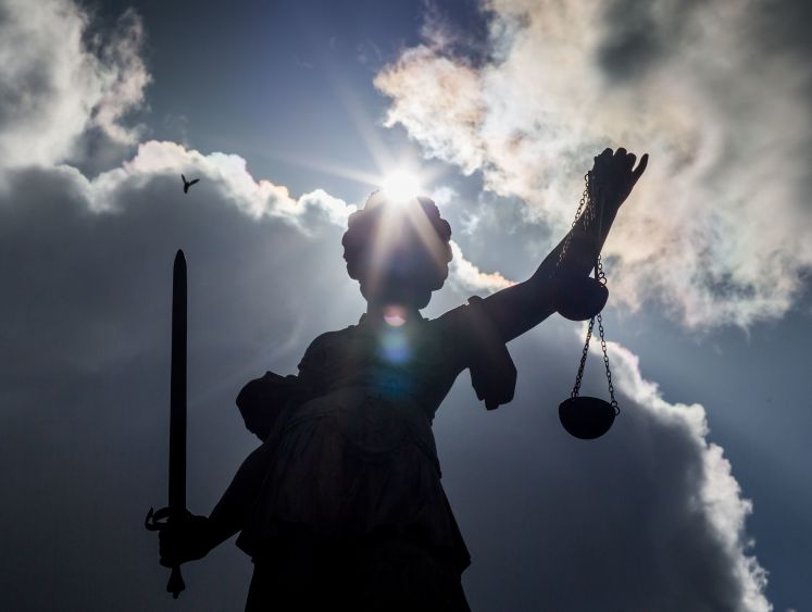 Die Sonne schaut am 26.04.2016 in Frankfurt am Main (Hessen) hinter der Statue der Justitia auf dem Gerechtigkeitsbrunnen auf dem Römerberg hervor