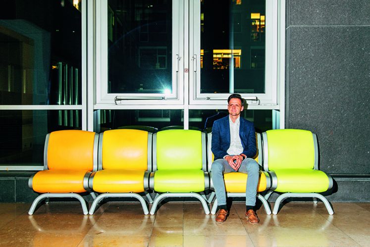 Müde wartet Klinge auf einer gelben Sitzreihe auf den Fahrdienst des Bundestages