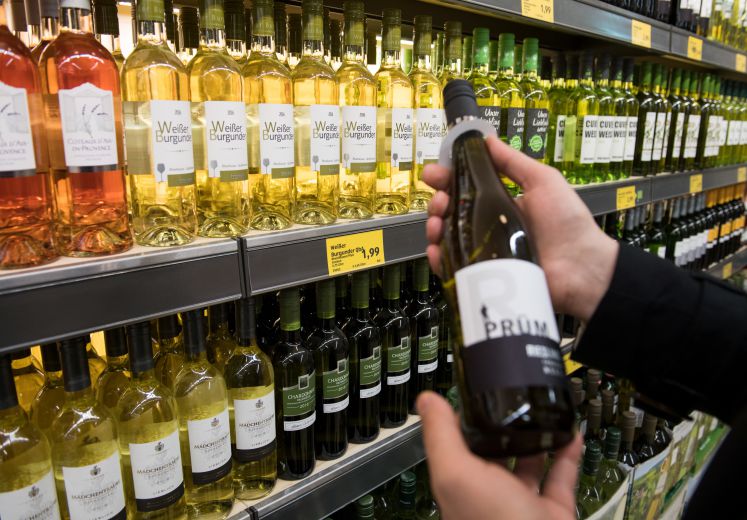 Ein Mann steht am 23.03.2017 in einer Filiale von Aldi Süd in Mülheim an der Ruhr (Nordrhein-Westfalen) vor einem Weinregal und betrachtet eine Flasche Riesling