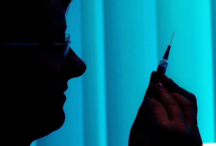 Eine Schwester mit einer Spritze im Gegenlicht