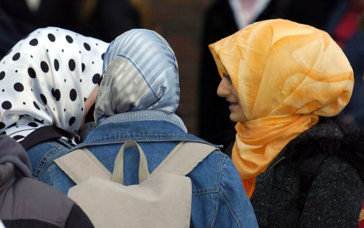 Drei Schülerinnen mit Kopftuch unterhalten sich am Donnerstag (02.12.2004) während einer Pause auf dem Schulhof der Herbert-Grillo-Gesamtschule in Duisburg.