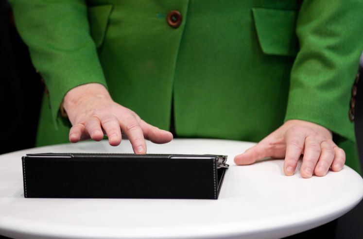 Bundeskanzlerin Angela Merkel (CDU) tippt 2015 in Hannover auf der weltweit größten Computermesse CeBIT auf einem Tablet-Computer.
