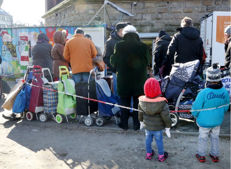 Kunden der Essener Tafel stehen mit ihren Einkaufstrolleys vor der Ausgabestelle. Die Essener Tafel will keine nichtdeutschen Neukunden mehr aufnehmen