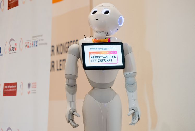 Roboter Pepper steht bei der Messe Altenpflege 2018. Er ist 1,20 Meter groß, hat kugelrunde Augen und bewegt sich auf Rollen freundlich auf die Menschen zu. Roboter Pepper könnte bald in deutschen Pflegeheimen zum Einsatz kommen und Bewohner mit Musik und Pantomime unterhalten oder zu Bewegungs-Übungen anleiten. Derzeit soll der von Informatikern der Universität Siegen programmierte kleine Kerl eine gesellschaftliche Diskussion über den Einsatz von Robotern in der Pflege anregen.