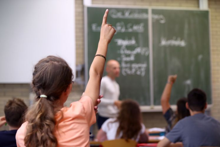 Eine Schülerin der fünften Klasse am Friedrich-Dessauer-Gymnasium (FDG) in Aschaffenburg (Bayern) hebt am 19.07.2017 im Unterricht den Finger.