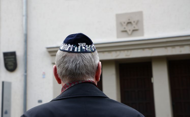 Teilnehmer einer Demonstration mit einer Kippa im Stadtzentrum von Erfurt vor der Neuen Synagoge nehmen Stellung gegen Antisemitismus und Ausgrenzung.