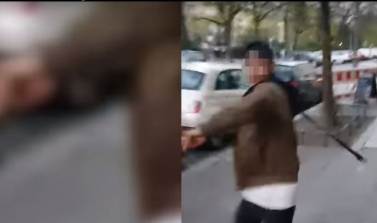 Mit einem Gürtel schlägt ein offenbar arabischstämmiger junger Mann auf einen Isreali ein