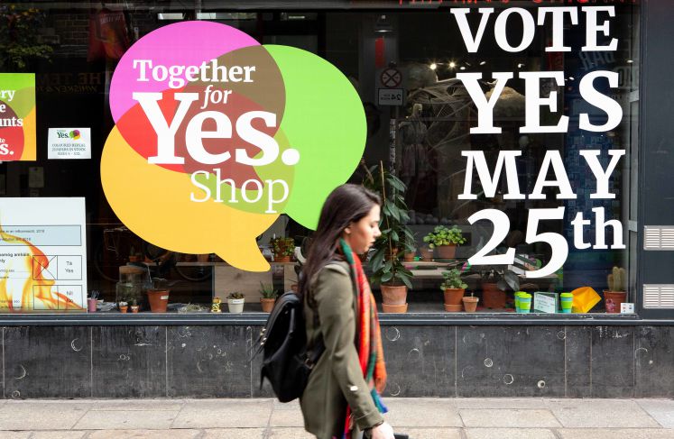  Irland, Dublin: Eine Passantin geht an einem Schaufenster im Stadtteil Temple Bar vorbei, in dem dafür geworben wird, beim Referendum für die Abschaffung des Verfassungszusatzes zum Abtreibungsverbot zu stimmen
