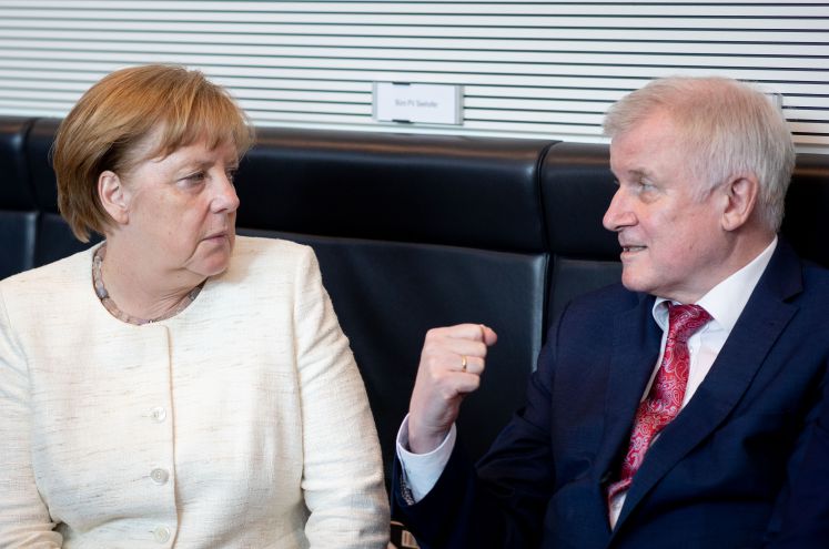 13.06.2018, Berlin: Bundeskanzlerin Angela Merkel (CDU) spricht mit Horst Seehofer (CSU), Bundesminister für Inneres, Heimat und Bau, vor Beginn der Sitzung des Bundeskabinetts im Kanzleramt.