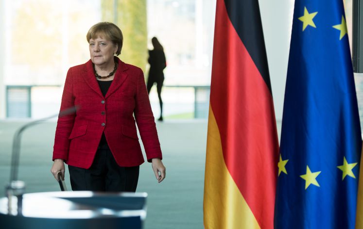 Angela Merkel vor Flaggen von Deutschland und der EU 
