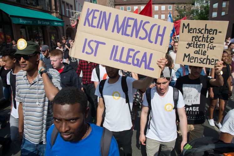 Teilnehmer einer Demonstration protestieren am 02.06.2017 in Nürnberg (Bayern) mit Schildern mit den Aufschriften "Menschenrechte gelten für alle Menschen" und "Kein Mensch ist illegal" gegen die bayerische Abschiebepraxis von Flüchtlingen.
