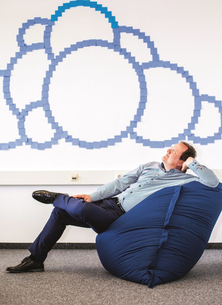 Holger Dyroff sitzt in einem Sitzsack und sieht entspannt nach oben