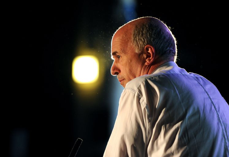 Carl-Peter Forster von der Seite fotografiert, am Podium vor einem Mikrofon stehend