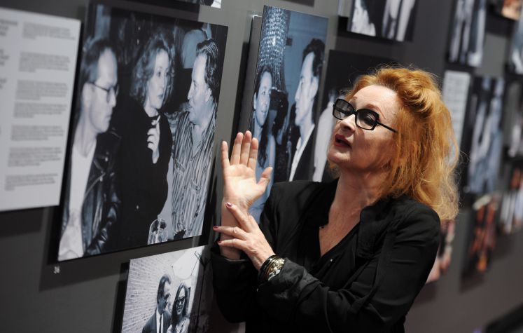 Die Sängerin und Schauspielerin Ingrid Caven kommt am Montag (02.07.2012) in München (Oberbayern) zum Filmfest München ins Gasteig zur Hommage an den Regisseur Fassbinder und deutet auf ein Foto, auf dem sie mit dem Schriftsteller Wolf Wandratschek und dem Komponist Peer Raben zu sehen ist.