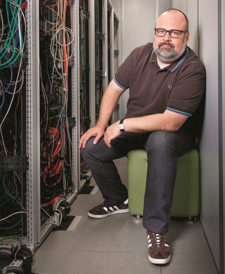 Timo Kobbs sitzt neben einem großen Kabelsalat