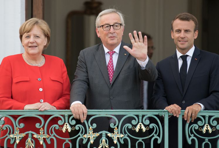 EU-Kommissionspräsident Jean-Claude Juncker mit Bundeskanzlerin Angela Merkel und Frankreichs Präsident Emmanuel Macron auf dem Balkon von Schloss Meseberg 