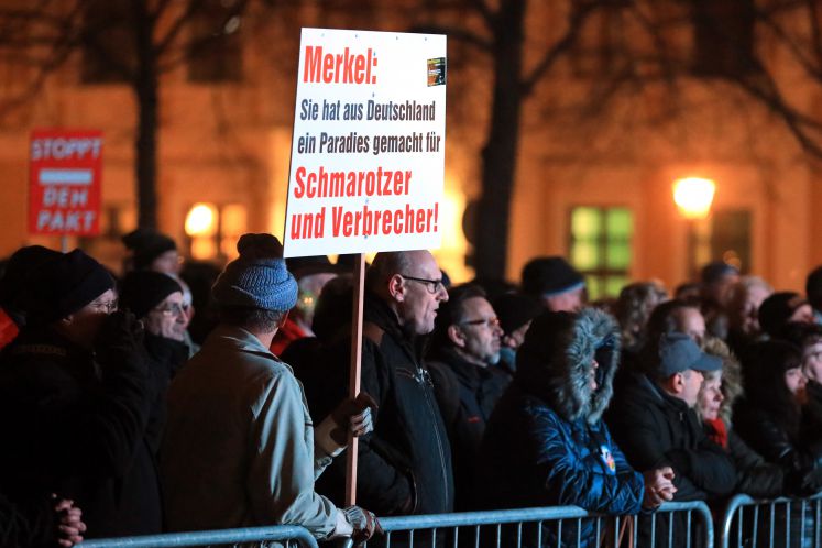 22.11.2018, Sachsen-Anhalt, Magdeburg: Demonstrationsteilnehmer stehen auf einer Kundgebung der AfD-Landtagsfraktion Sachsen-Anhalt gegen den UN-Migrationspakt auf dem Domplatz