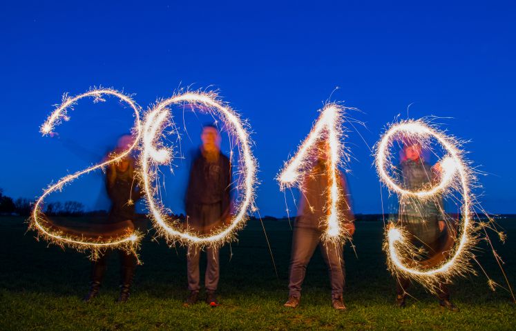 30.12.2018, Mecklenburg-Vorpommern, Dranske: ILLUSTRATION - Vier Personen schreiben mit Wunderkerzen die Jahreszahl 2019 in den Abendhimmel auf einem Feld auf der Ostseeinsel Rügen.